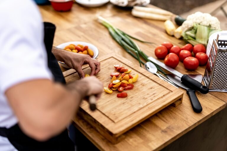 Chef preparing vegetables on a cutting board for mise en place